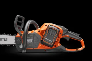 Set fra siden af en Husqvarna-kædesav, der fremhæver batterirummet.
