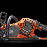 Set fra siden af en Husqvarna-kædesav, der fremhæver batterirummet.