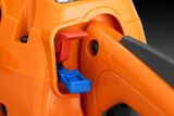 Close-up view of a chainsaw's control panel with a red and blue switch.