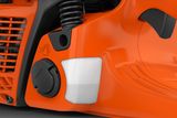 Вид крупним планом паливного бака та кришки ланцюгової пилки Husqvarna.