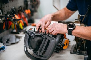 A person assembling or repairing a product in a workshop setting.