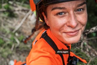 Une personne en tenue de travail avec un visage flouté, peut-être en train de travailler à l’extérieur.