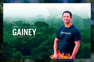 A person wearing work gear stands in front of a lush forest backdrop, with the name Chad Gainey displayed.