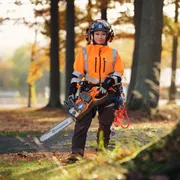 HUSQVARNA 550i XP®. A person in work gear holding a Husqvarna chainsaw in a forest setting.