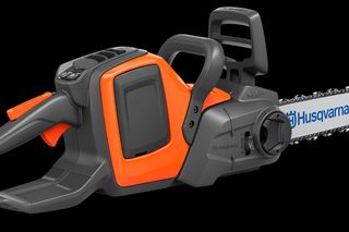 Side view of a Husqvarna chainsaw with ergonomic handle and visible branding.