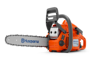 Side view of a Husqvarna chainsaw, showcasing its ergonomic handle and cutting chain.