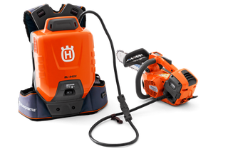 通过电缆连接的 Husqvarna 富世华电池背包和链锯的前视图。