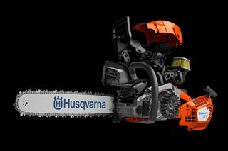 Side view of a Husqvarna chainsaw with visible internal components, including the engine and air filter.