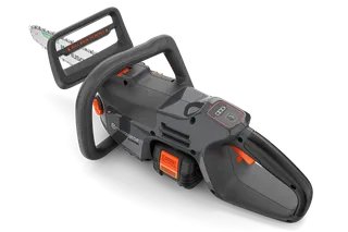 Bočný pohľad na reťazovú pílu Husqvarna s viditeľnou priehradkou na batérie a ergonomickou rukoväťou.