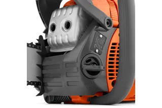 Close-up view of a chainsaw engine and handle, showcasing the air filter and control panel.