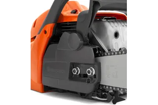Close-up view of a Husqvarna chainsaw, focusing on the chain and engine housing.