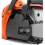Close-up view of a Husqvarna chainsaw, focusing on the chain and engine housing.