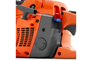 Close-up view of a chainsaw's side panel, showing the air filter cover and control levers.