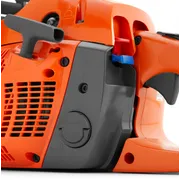 Close-up view of a chainsaw's side panel, showing the air filter cover and control levers.