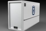 Side view of a Husqvarna storage container with a roller door.