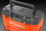 Зарядний пристрій Husqvarna C1000X4  великим планом із ручкою та світлодіодними індикаторами.