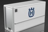 Side view of a large container with a Husqvarna logo on a reflective surface.