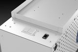 Close-up of a metal enclosure with ventilation holes and a power socket.