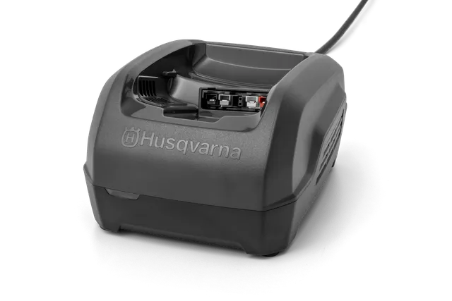 Vue de face d’un chargeur de batterie Husqvarna avec des ports de connexion visibles.