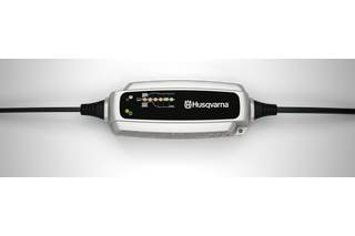 Top view of a Husqvarna battery charger with indicator lights.