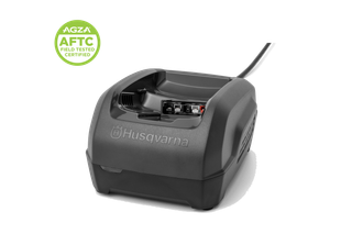 Vue de face d’un chargeur de batterie Husqvarna avec cordon d’alimentation et insigne de certification AGZA AFTC.