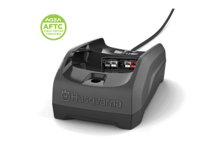 Front view of a Husqvarna robotic lawn mower charging station with power cable.