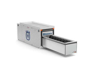 Side view of a Husqvarna robotic lawn mower charging station with a drawer partially open.