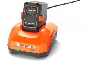 Front view of a Husqvarna C500X battery charger with a battery attached.