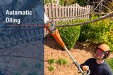 A person using a pole saw to trim tree branches in a garden, with 'Automatic Oiling' text overlay.