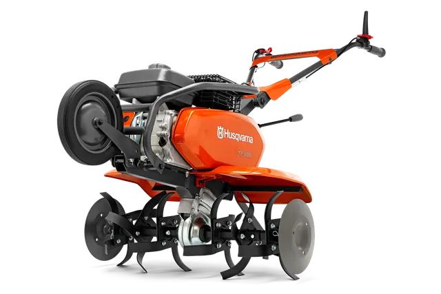 Вид збоку на культиватор Husqvarna з видимими лезами та рукояткою.