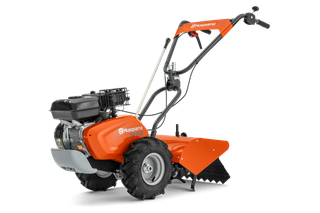 Side view of a Husqvarna tiller with ergonomic handle and robust wheels.