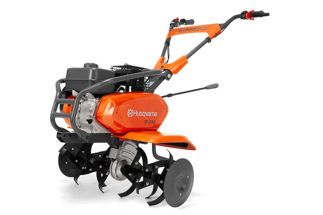 Side view of a Husqvarna TF 230 tiller showcasing its blades and handle.