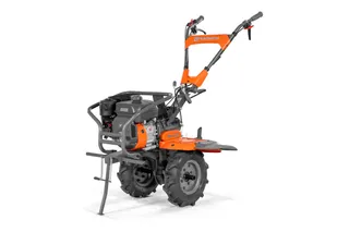 Вид збоку на культиватор Husqvarna з міцними колесами й ергономічними рукоятками.