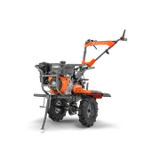 Husqvarna TF 545P. Side view of a Husqvarna walk-behind garden tiller showing handlebar, engine and treaded wheels.
