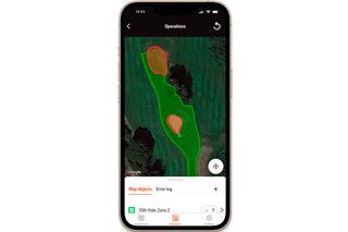 Smartphone displaying a garden map with marked zones for a robotic lawn mower.