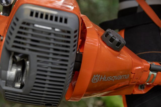Närbild på en Husqvarna-produkt, troligen ett motorverktyg, med fokus på dess komponenter.