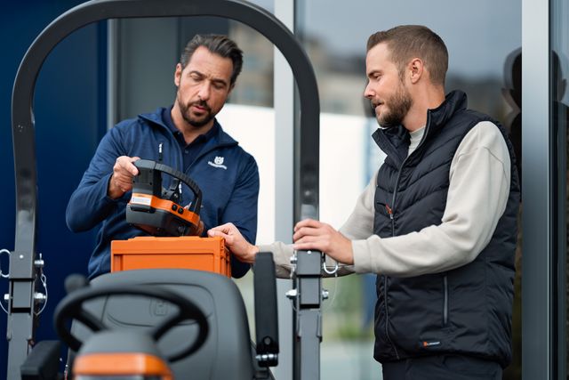Two people interacting with a product in an outdoor setting, one holding a component.