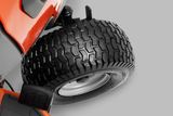 Close-up view of a lawn mower's rear wheel with a tread pattern.