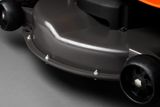 Close-up view of a lawn mower cutting deck with wheels and bolts.
