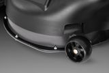 Close-up view of a lawn mower's cutting deck and wheel.