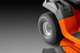 Close-up view of a ride-on mower's rear wheel and fender.