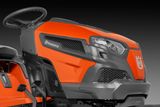 Közeli kép a Husqvarna fűnyíró elülső részéről, bemutatva annak dizájnját és márkajelzését.