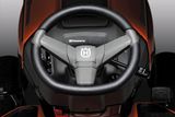 Top view of a Husqvarna ride-on mower steering wheel with control buttons.