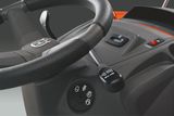 Close-up of a Husqvarna ride-on mower's steering wheel and control panel.