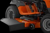 Close-up view of a ride-on mower's cutting deck and rear wheel.