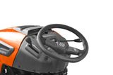Close-up view of a Husqvarna ride-on mower steering wheel and control panel.