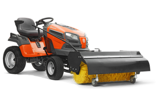 Zijaanzicht van een Husqvarna zitmaaier uitgerust met een aan de voorzijde gemonteerde veegmachine.