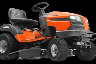 Side view of a Husqvarna ride-on lawn mower with visible steering wheel and seat.