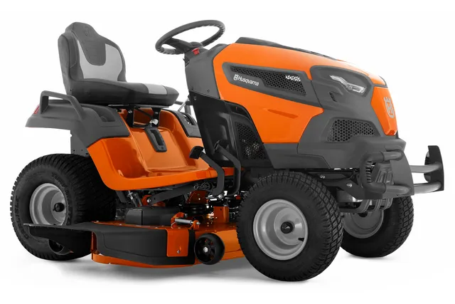 Side view of a Husqvarna ride-on lawn mower, showcasing its cutting deck and steering wheel.