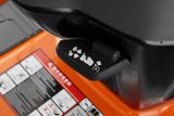 Close-up of a control lever on a Husqvarna product with safety instructions visible.